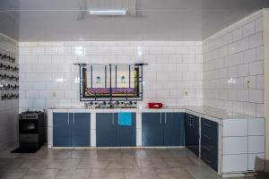a kitchen with blue cabinets and a window at Rijsdijk appartementen in Lelydorp