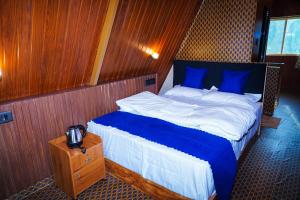 a bedroom with a bed with blue pillows on a boat at DreamNest Vagamon in Vagamon