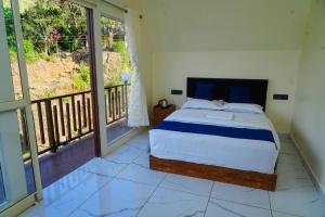 a bedroom with a bed and a balcony at DreamNest Vagamon in Vagamon