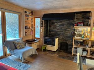 a living room with a stone fireplace and a chair at Natura Sauna in Laulasmaa