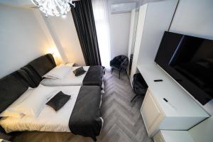 a bedroom with two beds and a flat screen tv at Sunrise Rooms in Bucharest +24 photos