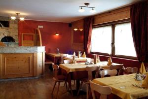 restauracja ze stołami i krzesłami w pokoju w obiekcie Hotel Adele w Livigno