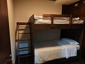 two bunk beds in a room with a ladder at Under the rocks luxury in Kalabaka
