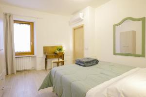 a white bedroom with a bed and a mirror at Alloggio turistico Alla Vasca in Tregnago
