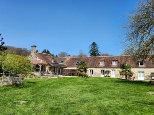 an exterior view of a large house with a yard at La Brocherie in Magny-le-Désert