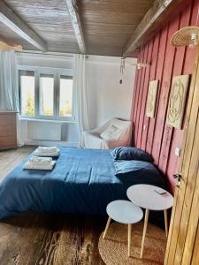 a bedroom with a blue bed and two white tables at Le Gîte de Hildegarde in Granges-Aumontzey