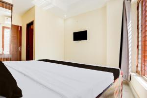 a bedroom with a bed and a tv on the wall at Hotel O Classic in in Kharar