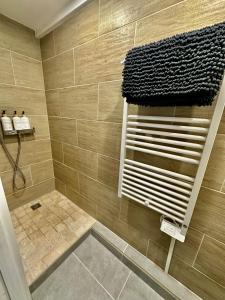 a tiled bathroom with a shower with a towel at Le Gîte de Hildegarde in Granges-Aumontzey +78 photos