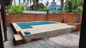 a swimming pool in front of a brick wall at Casa Rivadavia en El Paso in Paso de la Patria