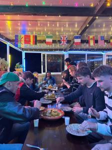 a group of people sitting at a table eating food at Ami d'or Hostel in Taghazout