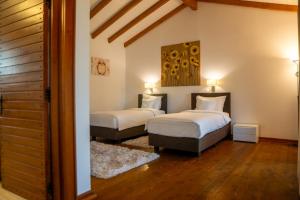 two beds in a room with wooden floors at Acacia Village in Ogrezeni +40 photos