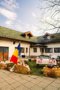 a house with hay bales and a flag in front of it at Acacia Village in Ogrezeni
