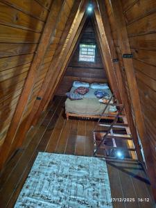 a bedroom with a bed in a wooden attic at Chalés Caraguatatuba in Caraguatatuba