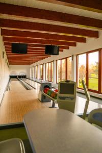 a bowling alley with pins and chairs in a building at Acacia Village in Ogrezeni