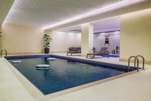 a large swimming pool in a building with a swimming pool at فندق ترى النزهة -Tura Hotel AlNuzha in Riyadh