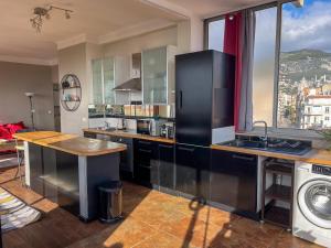 a kitchen with a black refrigerator and a sink at Grand T3-CLIM-WIFI-Vue in Toulon