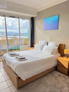 a bedroom with a large bed with a large window at Grand T3-CLIM-WIFI-Vue in Toulon