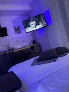 a bedroom with a bed with a tv on the wall at All in relaxation in Toulouse