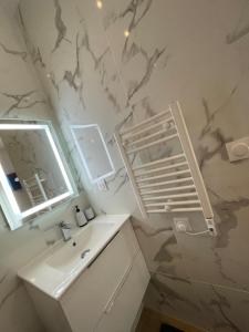 a white bathroom with a sink and a mirror at All in relaxation in Toulouse +12 photos