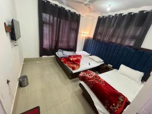 a room with two beds and a tv in it at Golden Mud in Srinagar
