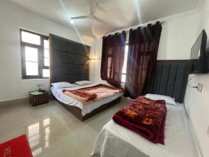 a bedroom with two beds in a room at Golden Mud in Srinagar