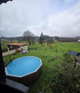 a swimming pool in the middle of a green field at Camiño da Vieira in Padrón