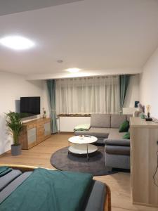 a living room with a couch and a table at Ferienwohnung zur Honigschleife in Langweiler