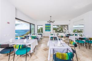 a restaurant with white tables and chairs and windows at La Demeure in Sidi Bou Saïd