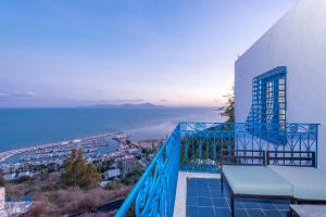 a balcony with a blue railing with a view of the ocean at La Demeure in Sidi Bou Saïd