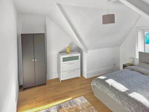 a bedroom with a bed and a dresser and a window at 3-Bed Duplex Flat, Free WIFI & Great Transport Links in Norwood