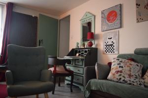 a living room with a table and chairs and a desk at Gite le GINKGO 50 M2 in Rougegoutte