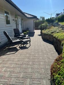 a patio with a bench and a table in front of a house at Large house with panoramic sea view in Bergen