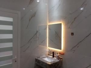 a bathroom with a sink and a mirror at Sumeras Sapphire Retreat in Ajman  +34 photos