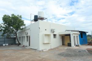 a white building with a water tank on top of it at Hotel Madurai Comforts in Madurai