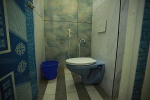 a bathroom with a blue toilet and a blue bucket at Hotel Madurai Comforts in Madurai