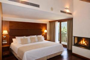 a bedroom with a large bed and a fireplace at Hotel Riberies & Spa by RdA Hotels in Llavorsí +58 photos