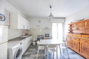 a kitchen with white cabinets and a table with chairs at Italian Experience-Mestrina Apartment in Mestre