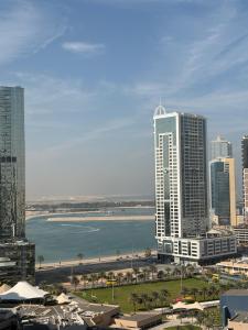 a city with tall buildings and a body of water at Panoramic Sea apartment & Skyline View Private Room in Sharjah