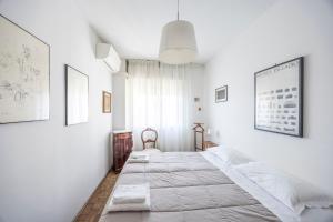 a white bedroom with two beds and a window at Italian Experience-Mestrina Apartment in Mestre
