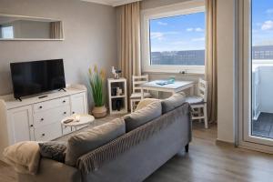 a living room with a couch and a tv at FeWo Deichnest in Brhv -Mitte Monteure in Bremerhaven