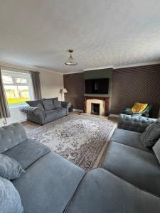 a living room with two couches and a fireplace at Magilligan Lodge in Bellarena Station