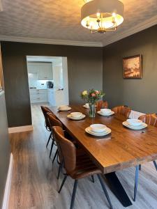 a dining room with a wooden table and chairs at Magilligan Lodge in Bellarena Station