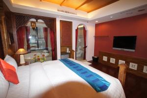 a bedroom with a large bed and a television at Xiu Feng in Kenting