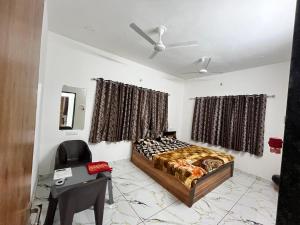a bedroom with a bed and a desk and curtains at Ranchhod Villa in Marwad +1 photo