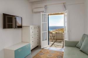 a living room with a couch and an open door at Emerald Bay 4BR with pool by Lia Beach in Mikonos