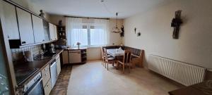 a kitchen with a table and a small table with chairs at Ferienwohnung Lene im Lauertal - Rhön in Maßbach +10 photos