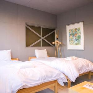 two beds sitting next to each other in a room at Hostel STAND BY ME in Fukuoka