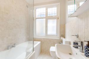 a bathroom with a tub and a toilet and a sink at 3-Bed Duplex Flat, Free WIFI & Great Transport Links in Norwood