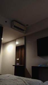 a bedroom with a bed and a television on the wall at Srt rajput hotel Subhash Marg Charbhag Lucknow in Lucknow
