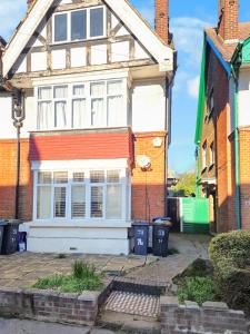 a white house with a red roof at 3-Bed Duplex Flat, Free WIFI & Great Transport Links in Norwood